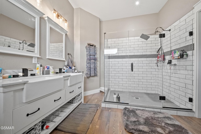 bathroom featuring wood-type flooring, vanity, and a shower with door