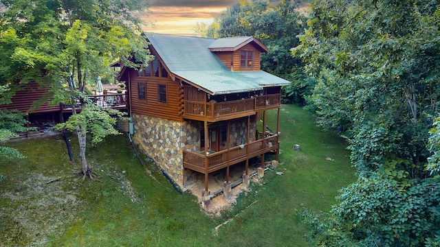 back house at dusk with a lawn and a wooden deck