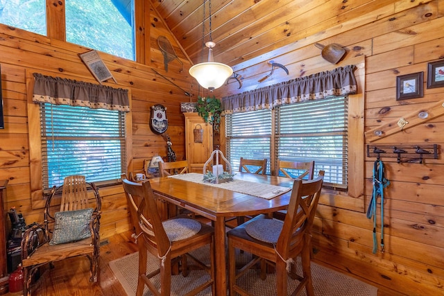 dining room featuring hardwood / wood-style floors, wooden ceiling, lofted ceiling, and wood walls