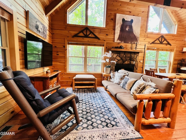 2527 Raccoon Hollow Way, Sevierville, TN 37862 - living area with high vaulted ceiling, wooden walls, a wood ceiling with exposed beams, and a stone fireplace