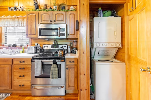 2210 Hawks Point Way, Sevierville, TN 37862 - kitchen with light countertops, appliances with stainless steel finishes, stacked washer and clothes dryer, and a sink