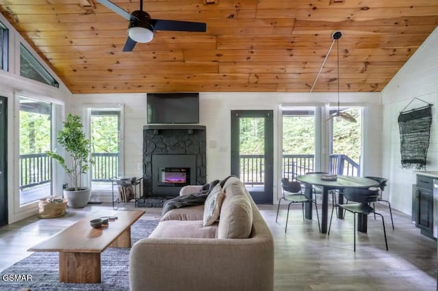 living room with a stone fireplace, wood ceiling, and vaulted ceiling