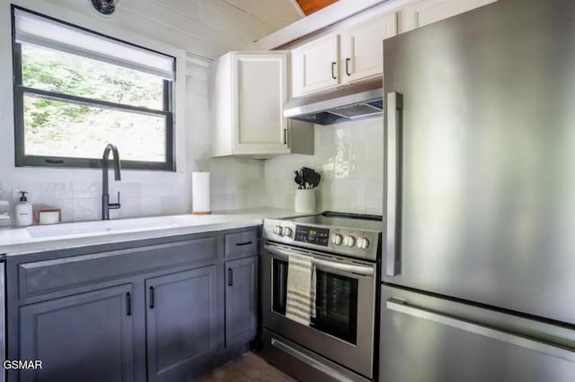 kitchen with backsplash, white cabinetry, sink, and appliances with stainless steel finishes