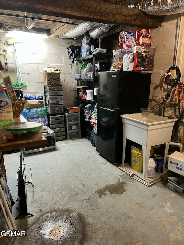 815 Hartsell Rd, Newport, TN 37821 - unfinished below grade area with concrete block wall and freestanding refrigerator