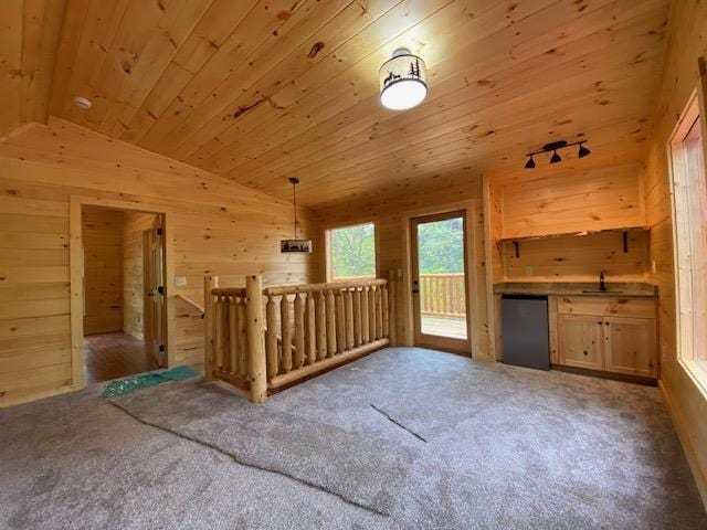 additional living space featuring wood walls, lofted ceiling, sink, carpet flooring, and wood ceiling