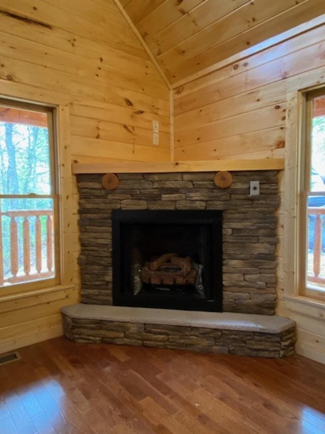 interior details featuring a fireplace, hardwood / wood-style floors, wooden walls, and wood ceiling