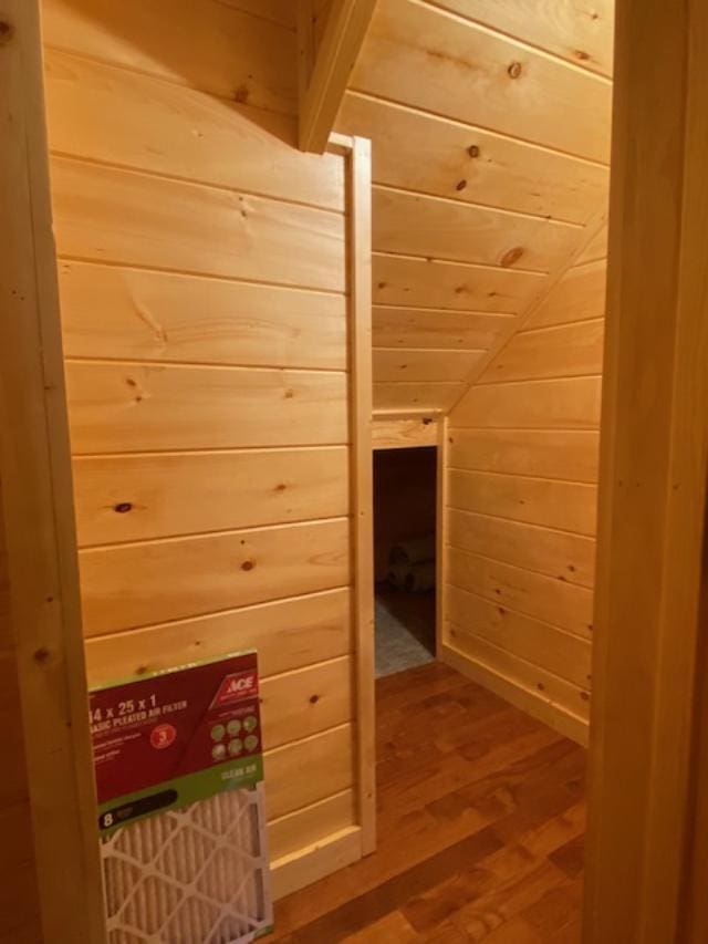 additional living space with lofted ceiling, wood-type flooring, wooden walls, and wooden ceiling