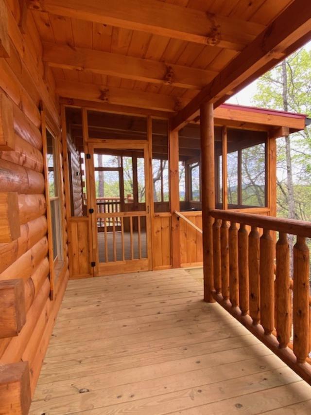 unfurnished sunroom with beamed ceiling, a healthy amount of sunlight, and wood ceiling