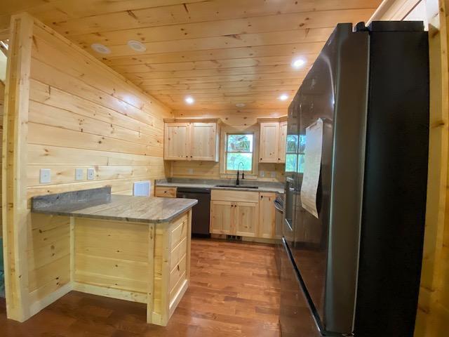 kitchen with wood ceiling, dark wood-style flooring, a sink, fridge with ice dispenser, and black dishwasher