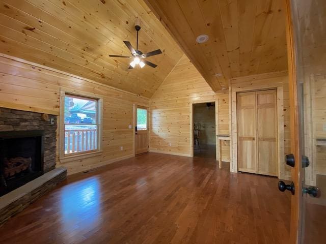 unfurnished living room featuring wood walls, a stone fireplace, ceiling fan, wood-type flooring, and wood ceiling