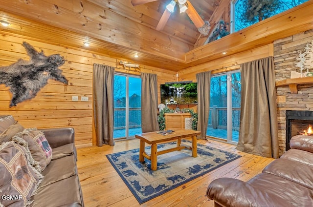 living room with high vaulted ceiling, ceiling fan, a fireplace, beamed ceiling, and light hardwood / wood-style floors