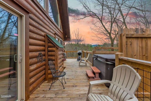 deck at dusk with a hot tub