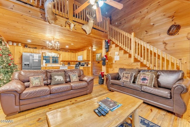 living room with wood walls, light hardwood / wood-style floors, ceiling fan with notable chandelier, and wooden ceiling