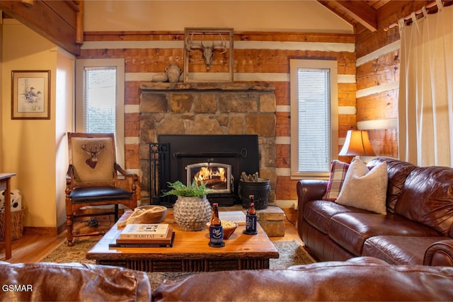 living area with wood finished floors and a stone fireplace