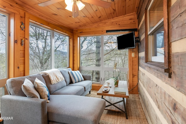 sunroom with lofted ceiling, wooden ceiling, a ceiling fan, and a wealth of natural light