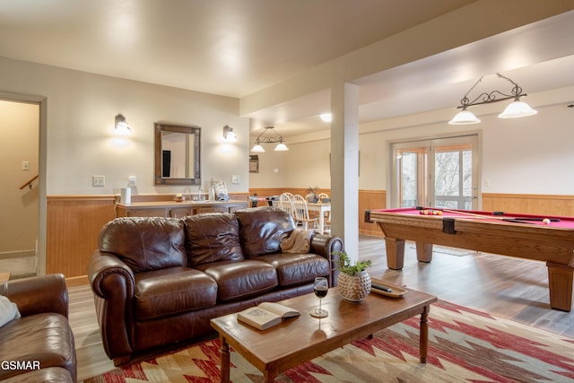 living area with pool table, wainscoting, and wood finished floors