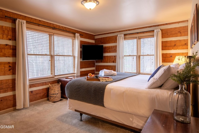 bedroom with wood walls, multiple windows, carpet, and baseboards