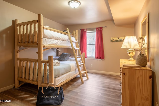 bedroom with baseboards and wood finished floors