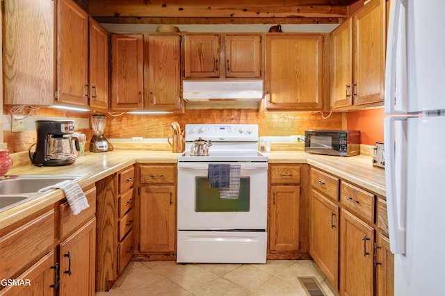 kitchen featuring white appliances, visible vents, range hood, light countertops, and light tile patterned flooring