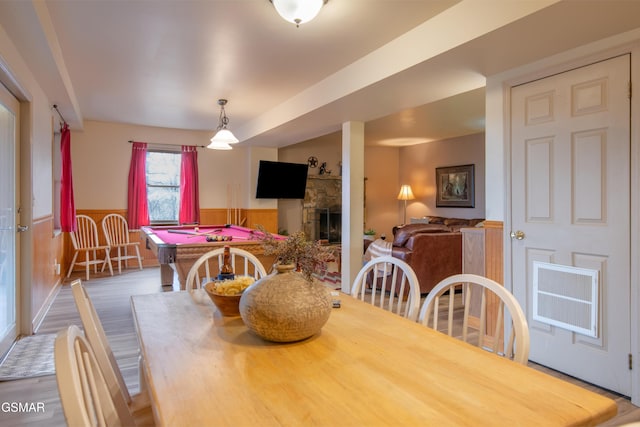 dining space with pool table, wood finished floors, wainscoting, and a fireplace