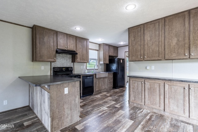 1138 Douglas Dam Rd, Dandridge, TN 37725 - kitchen with black appliances, under cabinet range hood, a peninsula, dark wood-style flooring, and dark countertops