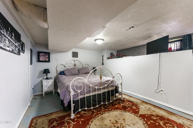 bedroom featuring a textured ceiling and concrete floors