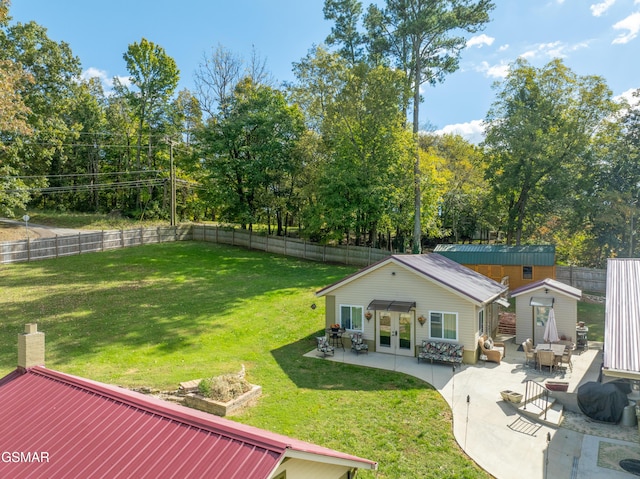 view of yard featuring french doors, a patio, and a storage unit