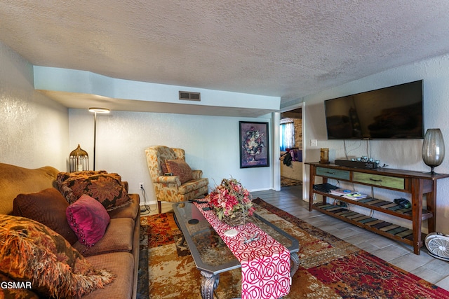 living room featuring a textured ceiling and hardwood / wood-style flooring