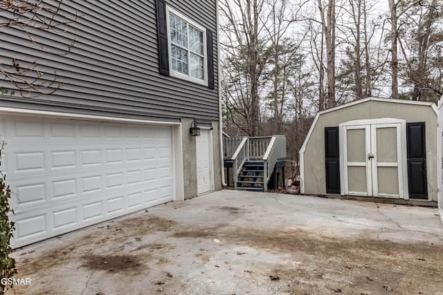 garage with concrete driveway and a shed