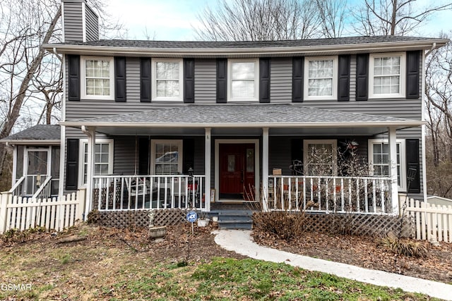 view of front of home with covered porch, roof with shingles, a chimney, and fence