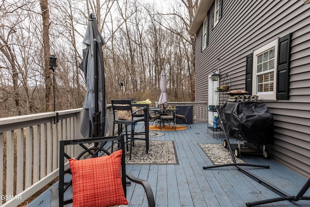 wooden deck featuring grilling area and outdoor dining area