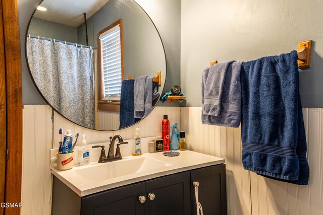 bathroom with a wainscoted wall and vanity