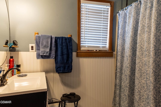 bathroom with a shower with curtain, vanity, and wainscoting