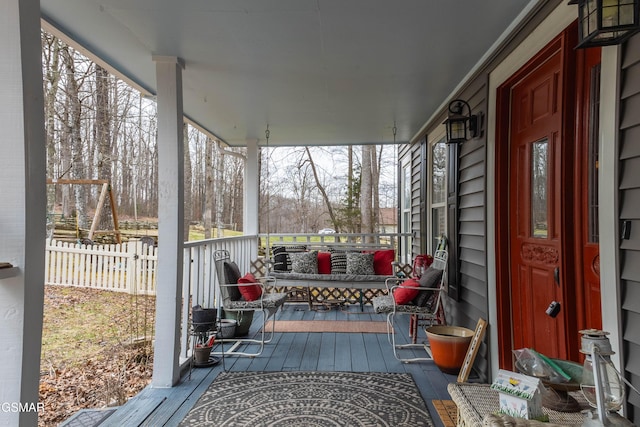 deck with a porch and fence