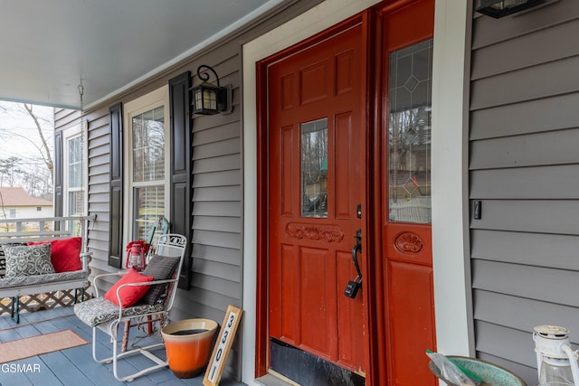 view of exterior entry featuring covered porch