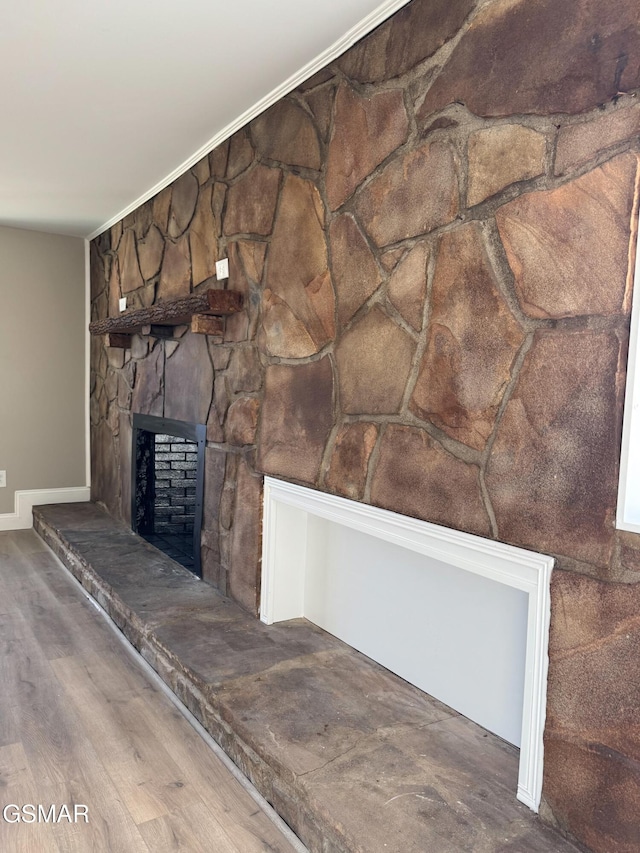 interior details featuring wood-type flooring and a stone fireplace