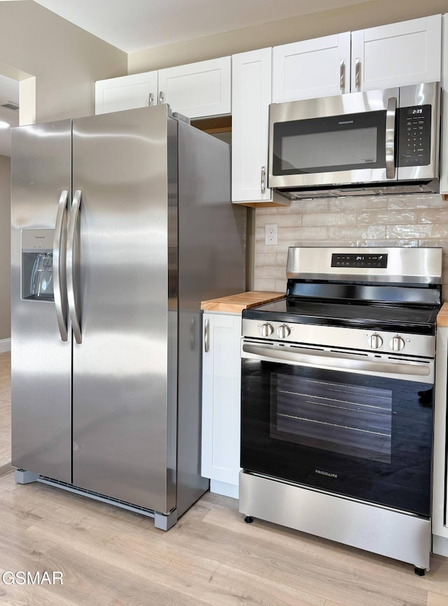 kitchen with appliances with stainless steel finishes, light hardwood / wood-style floors, decorative backsplash, and white cabinets