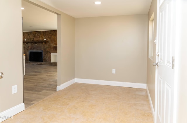 empty room featuring tile patterned floors and a stone fireplace