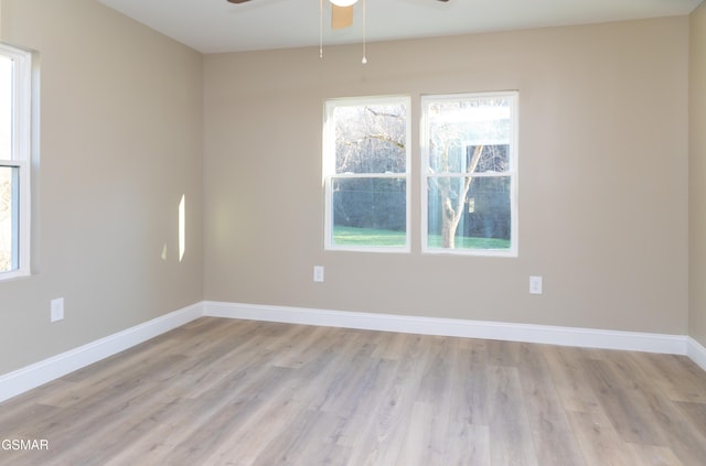 spare room with ceiling fan, a healthy amount of sunlight, and light hardwood / wood-style flooring