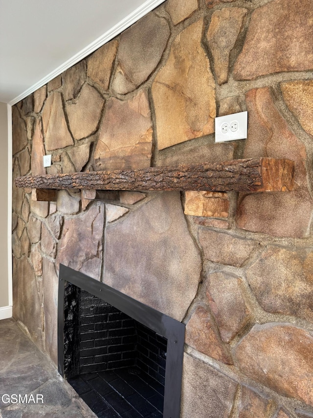 interior details featuring crown molding and a stone fireplace