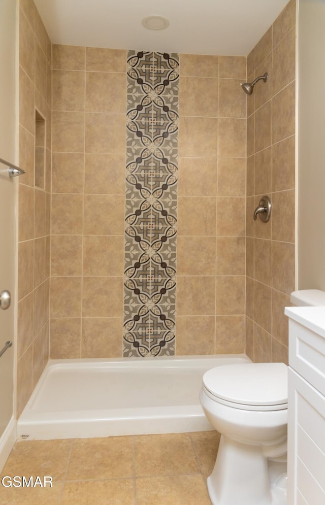 bathroom with vanity, toilet, and a tile shower