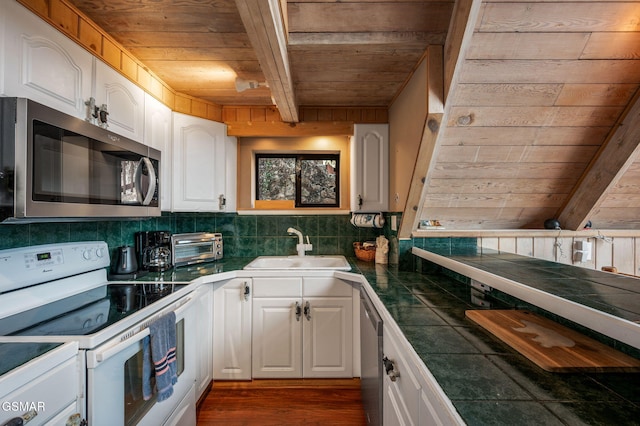 kitchen with wooden ceiling, stainless steel appliances, sink, and white cabinets