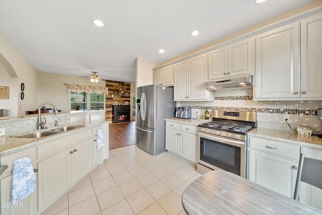 854 River Cliff Dr, Kodak, TN 37764 - kitchen with appliances with stainless steel finishes, under cabinet range hood, a sink, a large fireplace, and ceiling fan