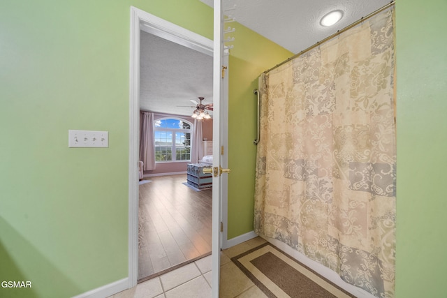 854 River Cliff Dr, Kodak, TN 37764 - full bath featuring a textured ceiling, baseboards, tile patterned floors, a ceiling fan, and curtained shower