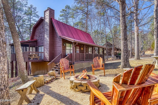 1785 Blue Ridge Rd, Sevierville, TN 37876 - rear view of house featuring a fire pit, metal roof, a chimney, stairs, and a wooden deck