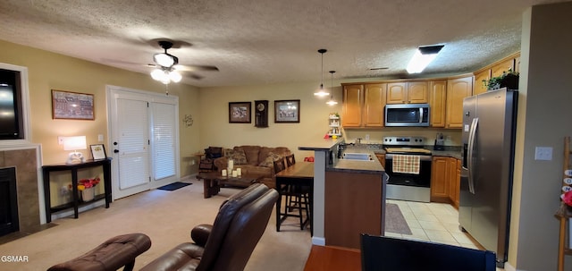1003 Woullard Way Unit 1, Sevierville, TN 37876 - kitchen featuring stainless steel appliances, a breakfast bar area, ceiling fan, open floor plan, and a textured ceiling