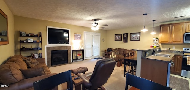 1003 Woullard Way Unit 1, Sevierville, TN 37876 - living room featuring ceiling fan, a tiled fireplace, a textured ceiling, and light colored carpet
