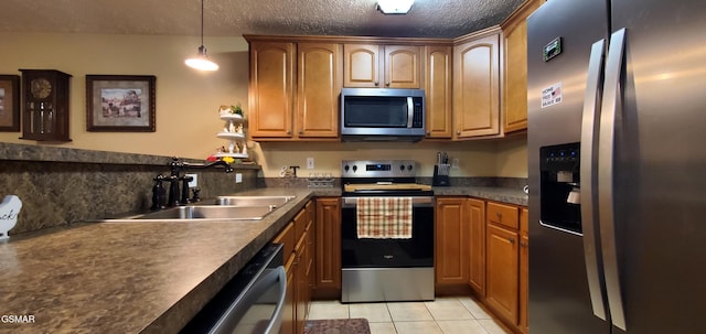 1003 Woullard Way Unit 1, Sevierville, TN 37876 - kitchen featuring stainless steel appliances, light tile patterned floors, dark countertops, decorative light fixtures, and a textured ceiling