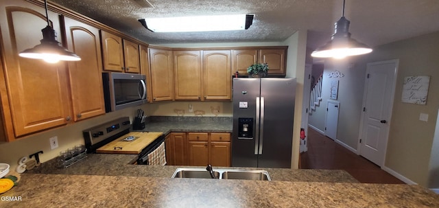1003 Woullard Way Unit 1, Sevierville, TN 37876 - kitchen with stainless steel appliances, hanging light fixtures, a textured ceiling, and brown cabinetry