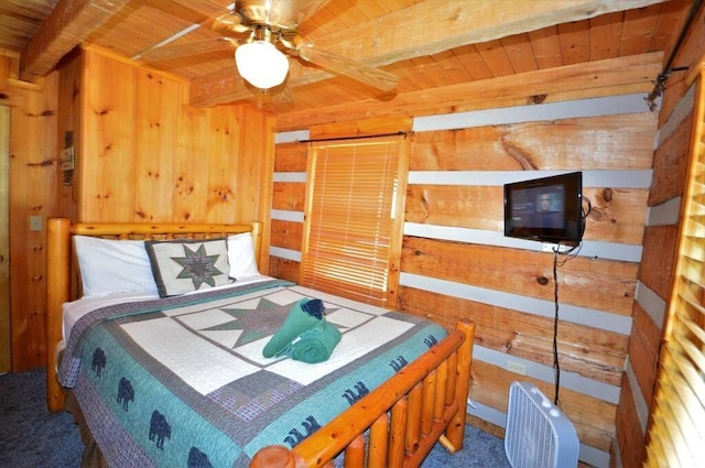 carpeted bedroom featuring wooden walls, beamed ceiling, wooden ceiling, and ceiling fan